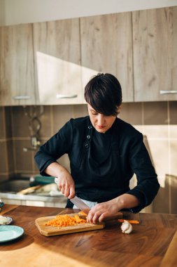 Tahtada havuç doğrayan kadın şef.