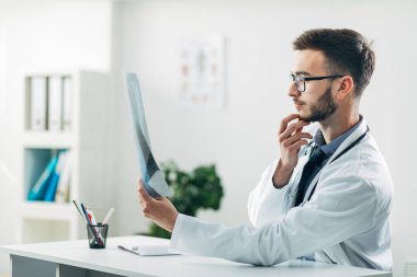 Doktor ofisinde röntgene bakıyor.