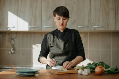 Şef mutfakta sebzeli bir tarif hazırlıyor.