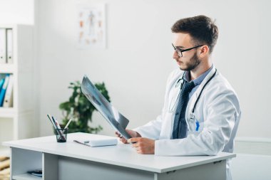 Doktor ofisinde röntgene bakıyor.