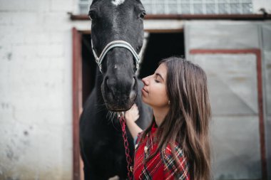 Ahırda atlı bir kız.