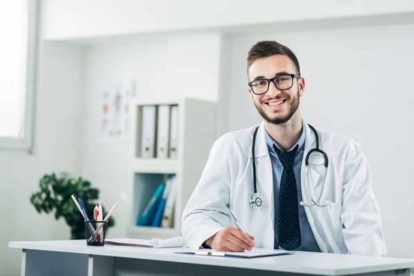 Genç Doktor Masasının Arkasında Ofisinde Oturuyor — Stok fotoğraf