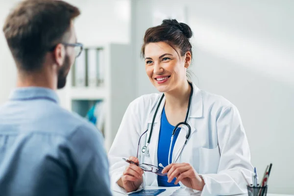 Doktor ve hasta doktorun ofisinde oturuyor.