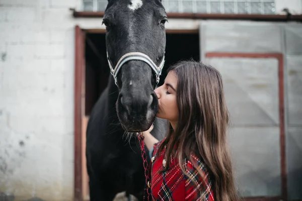 女の子接吻彼女のペット馬にザ厩舎 — ストック写真