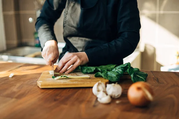 Шеф-повар режет сырые овощи на деревянной доске — стоковое фото