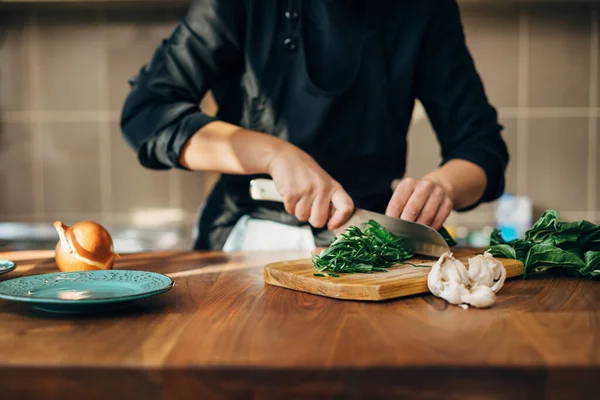 Chef hembra picando verduras crudas en una tabla de madera — Foto de Stock