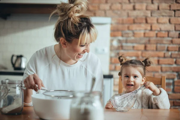 Madre e hija horneando galletas en su cocina — Foto de Stock