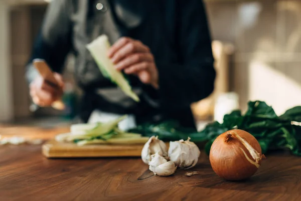 Female chef chopping raw vegetables on a wooden board — Stock Photo, Image