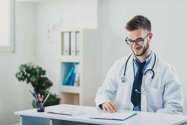 Jovem Médico Sentado Seu Escritório Atrás Uma Mesa — Fotografia de Stock