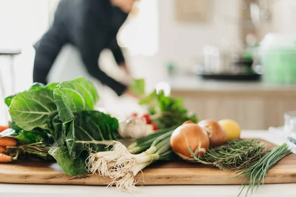 Varias verduras en una tabla de cortar de madera en la cocina — Foto de Stock