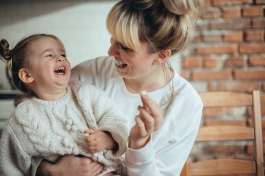 Anne ve kızı kurabiye pişiriyor ve sarılıyorlar.