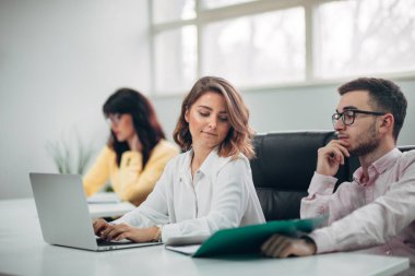 İş ekibi ofiste bir proje üzerinde çalışıyor.