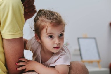 Babası kızı kollarında tutuyor.