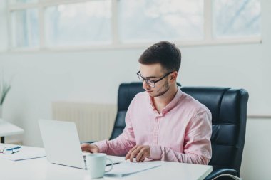 Genç adam ofiste bir proje üzerinde çalışıyor.