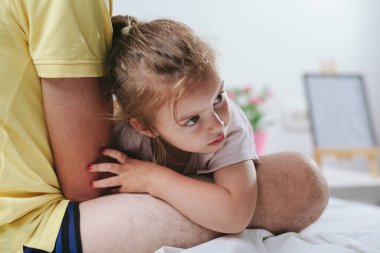 Babası kızı kollarında tutuyor.