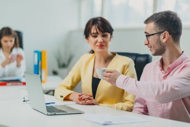 İş arkadaşları ofiste kahve içiyor.