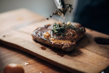 Ahşap tahtada pirzola servisi yapan kadın şef.