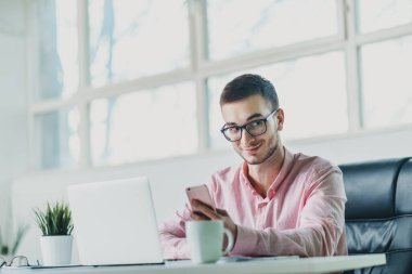 Genç adam ofiste bir proje üzerinde çalışıyor.