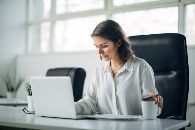 Genç bayan ofiste çalışıyor.