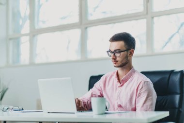 Genç adam ofiste bir proje üzerinde çalışıyor.