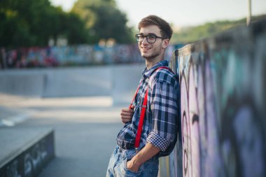 Gün batımında kaykay parkında genç bir adam