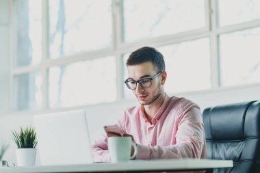 Genç adam ofiste bir proje üzerinde çalışıyor.