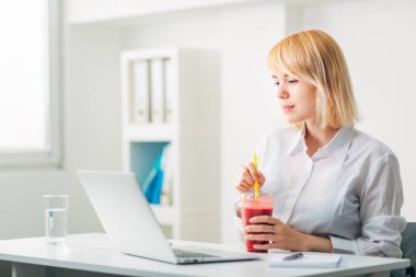 Ofiste e-posta okurken Smoothie içen Çekici Kadın