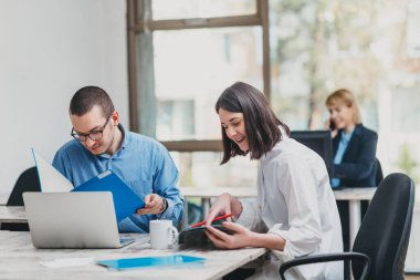 Ofisteki bir proje üzerinde çalışan meslektaşlar