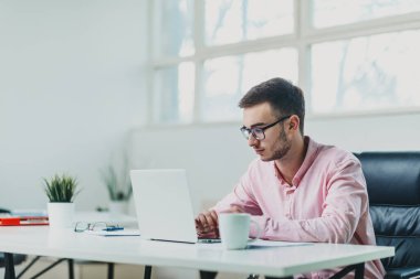 Genç adam ofiste bir proje üzerinde çalışıyor.