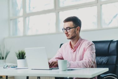 Genç adam ofiste bir proje üzerinde çalışıyor.