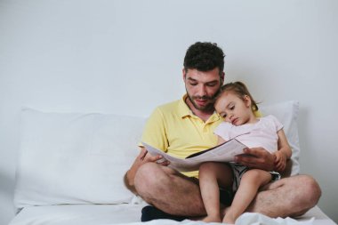 Baba kızına masal okuyor.