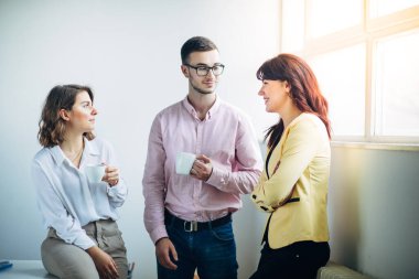 Mola sırasında iş arkadaşları ofiste sohbet ediyorlar.