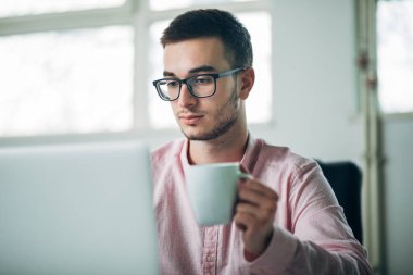 Genç adam ofiste bir proje üzerinde çalışıyor.