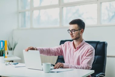 Genç adam ofiste bir proje üzerinde çalışıyor.