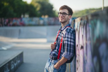 Gün batımında kaykay parkında genç bir adam