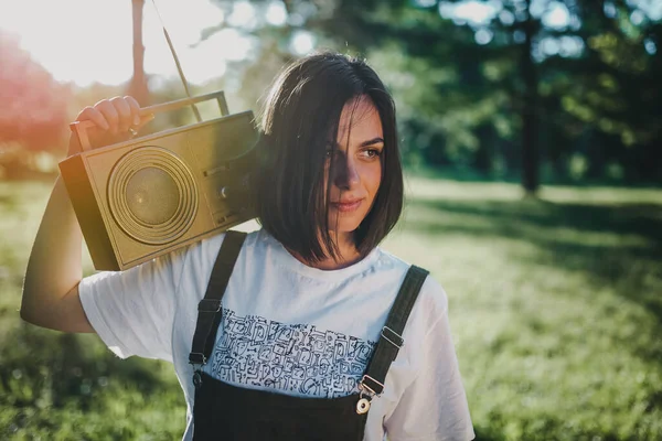 一个年轻少女日落时拿着收音机的画像 — 图库照片