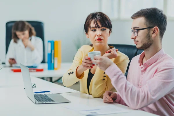 Colleagues drinking coffee at office