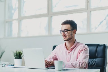 Genç adam ofiste bir proje üzerinde çalışıyor.