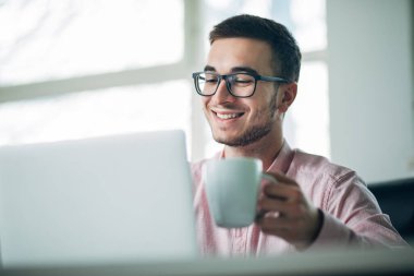 Genç adam ofiste bir proje üzerinde çalışıyor.