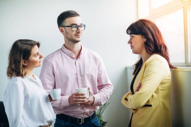 Mola sırasında iş arkadaşları ofiste sohbet ediyorlar.
