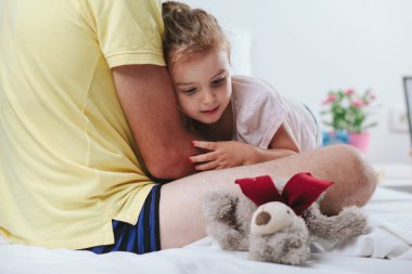 Babası kızı kollarında tutuyor.