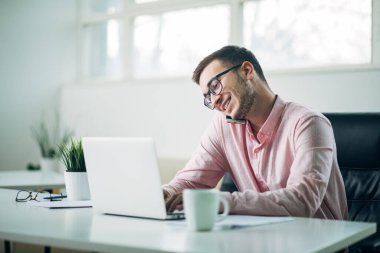 Genç adam ofiste bir proje üzerinde çalışıyor.