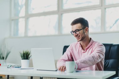 Genç adam ofiste bir proje üzerinde çalışıyor.