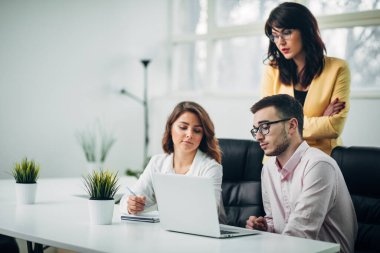 İş ekibi ofiste bir proje üzerinde çalışıyor.