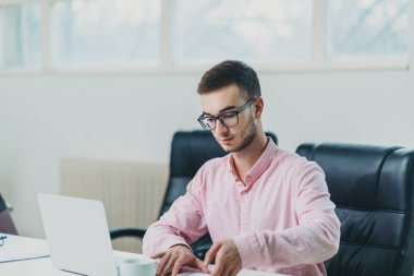 Genç adam ofiste bir proje üzerinde çalışıyor.