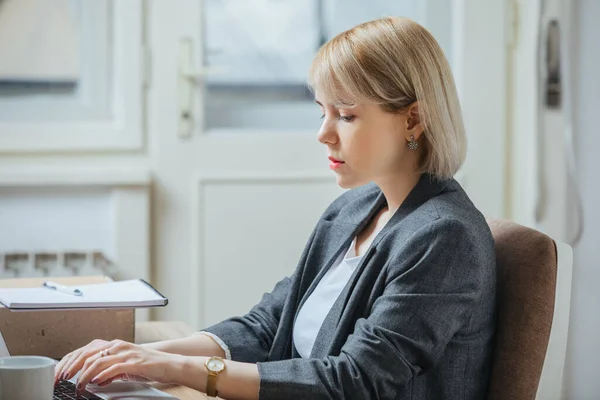 Young woman writing an email from the laptop