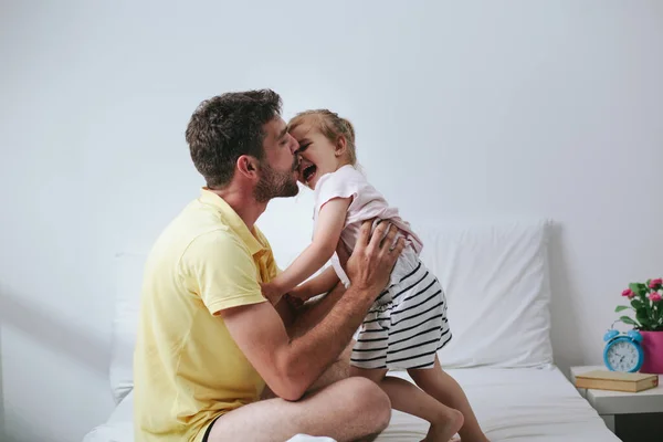 stock image Father and daughter playing on bed