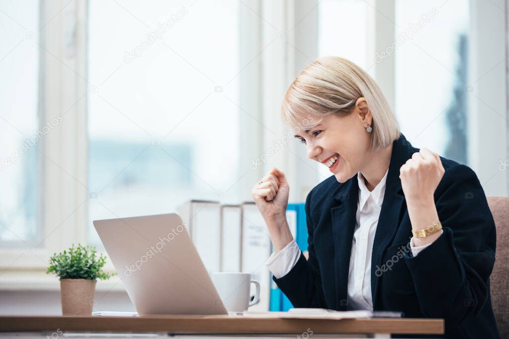 Young woman celebrating in her office