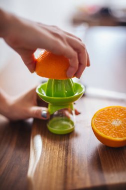 Kadın mutfakta portakal suyu yapıyor.