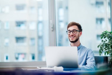 Dizüstü bilgisayarda çalışma ofisinde genç işadamı